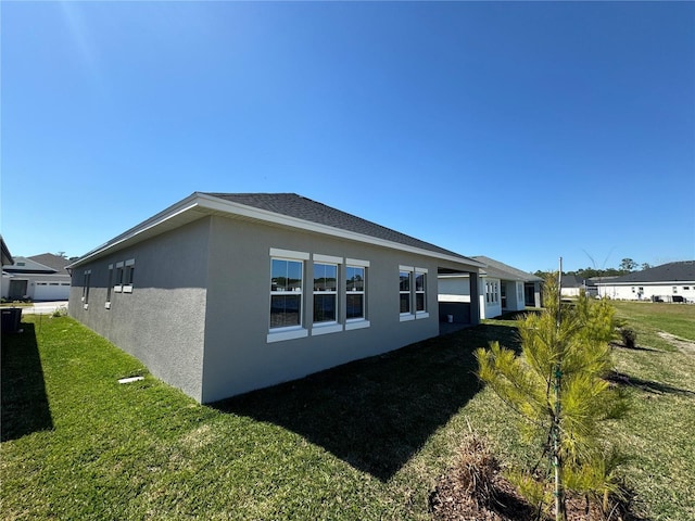 view of property exterior with stucco siding and a yard