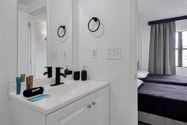 ensuite bathroom featuring ensuite bathroom, vanity, and a textured wall