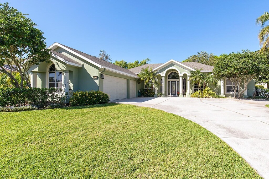 11139 Crooked River Ct, Clermont, FL 34711 - view of front of home featuring concrete driveway, an attached garage, a front yard, and stucco siding