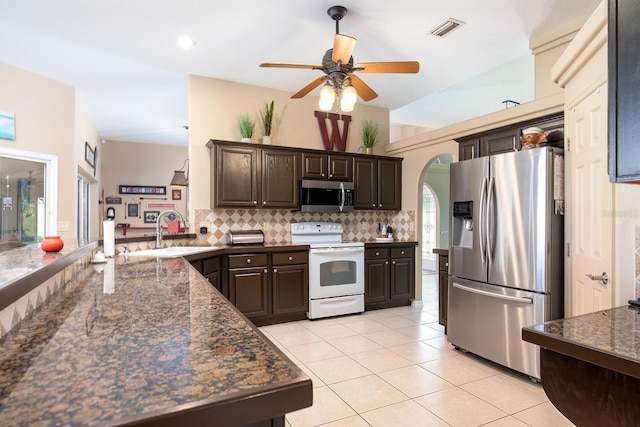 kitchen with visible vents, a sink, decorative backsplash, dark brown cabinetry, and appliances with stainless steel finishes