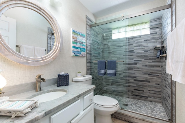 bathroom featuring vanity, toilet, and a stall shower