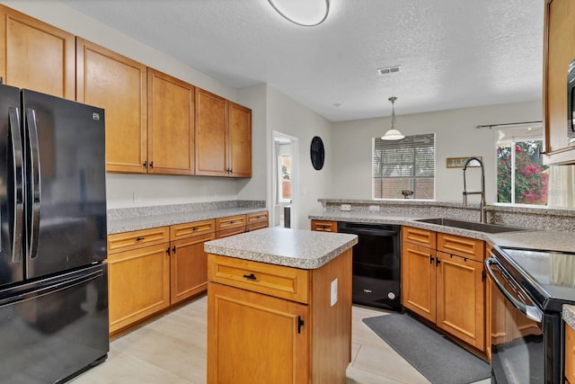 kitchen featuring visible vents, black appliances, a sink, a center island, and light countertops