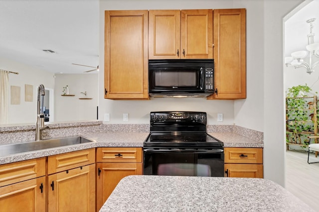 kitchen with visible vents, black appliances, light countertops, and a sink