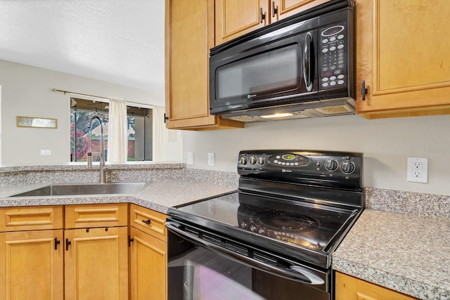 kitchen with black appliances, light countertops, and a sink