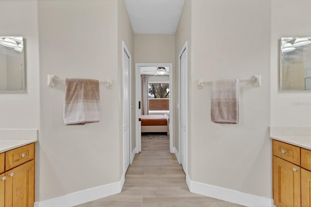 ensuite bathroom featuring ensuite bathroom, wood finished floors, baseboards, ceiling fan, and vanity