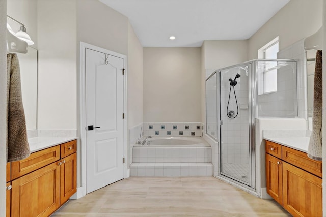 full bathroom featuring vanity, a bath, and a shower stall