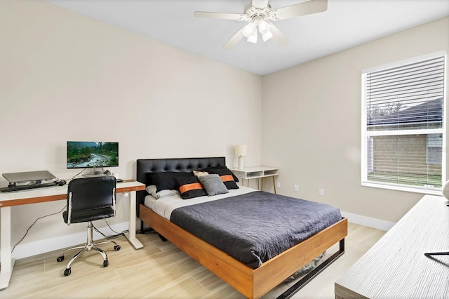 bedroom featuring a ceiling fan, baseboards, and light wood-type flooring