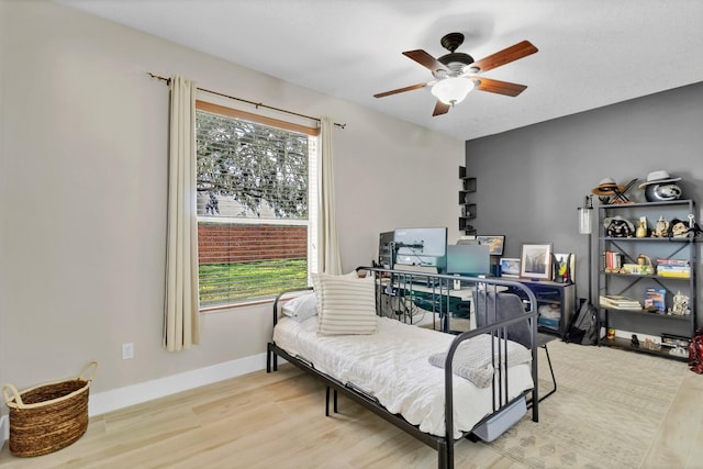 bedroom featuring a ceiling fan, wood finished floors, and baseboards