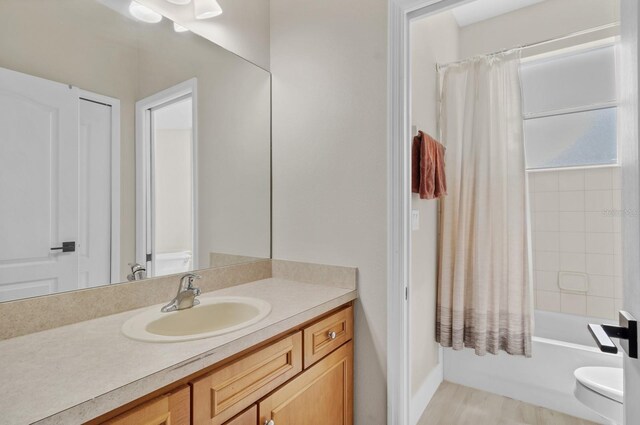 full bath featuring toilet, vanity, and shower / bathtub combination with curtain