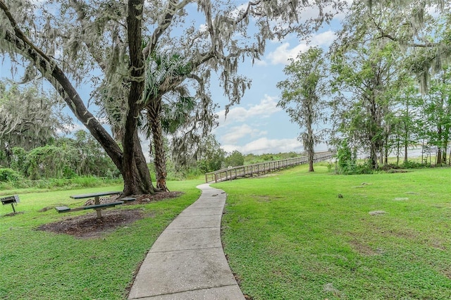 view of community featuring a yard and fence