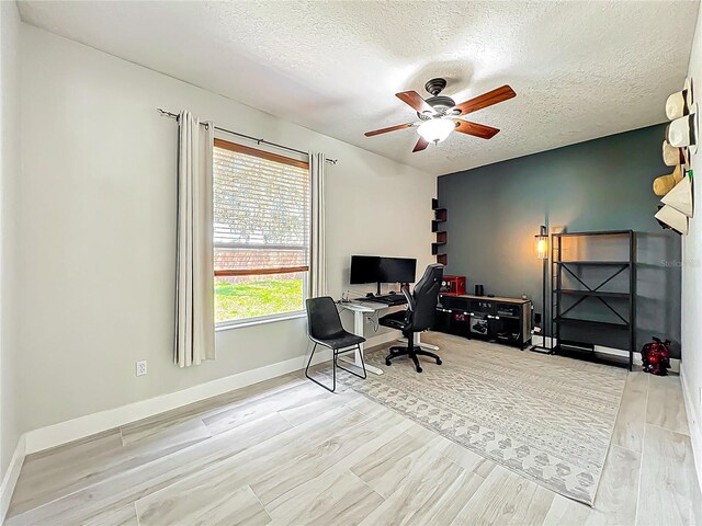 home office with baseboards, a textured ceiling, ceiling fan, and wood finished floors
