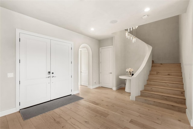 entrance foyer featuring light wood finished floors, recessed lighting, stairs, and baseboards