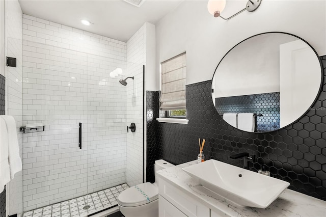 bathroom featuring toilet, a stall shower, and vanity