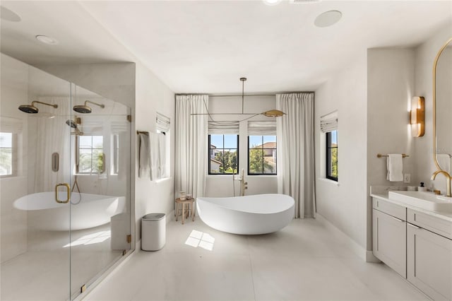 full bathroom featuring tile patterned floors, a freestanding tub, a stall shower, baseboards, and vanity