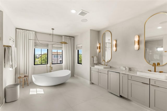 full bath featuring double vanity, visible vents, an enclosed shower, and a sink