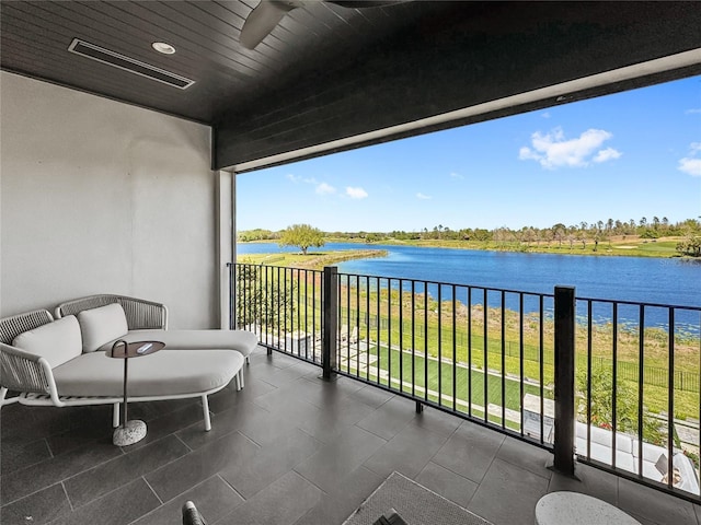 balcony featuring visible vents, a water view, and ceiling fan