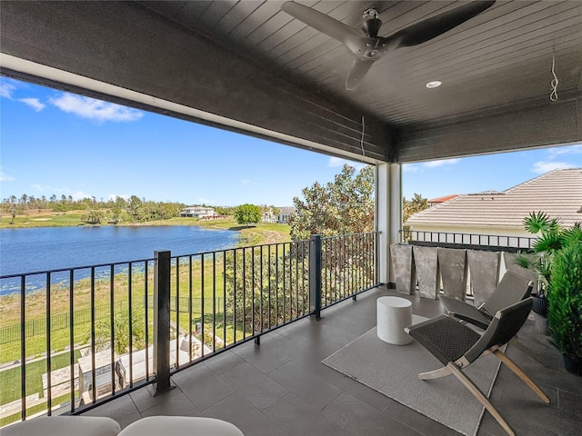 balcony featuring a water view and ceiling fan