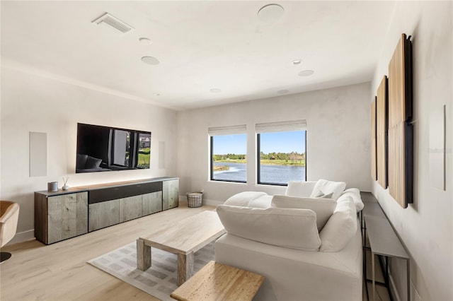 living area featuring wood finished floors, visible vents, and baseboards