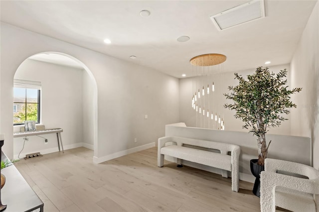 sitting room with visible vents, baseboards, recessed lighting, wood finished floors, and arched walkways