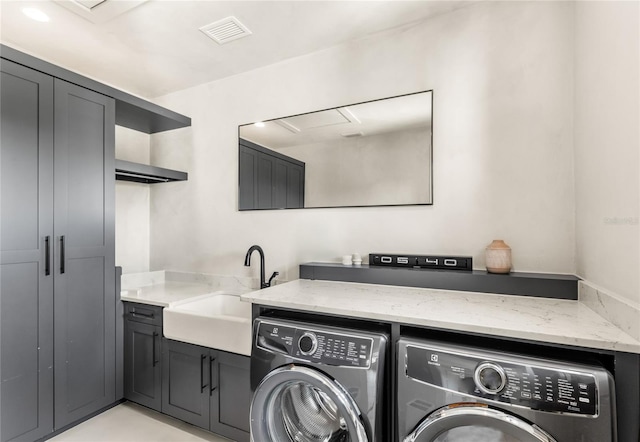 laundry area with cabinet space, washing machine and dryer, visible vents, and a sink