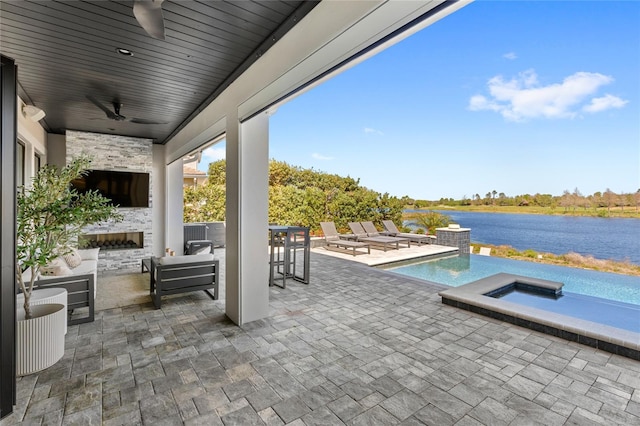 view of patio with an outdoor pool, a jacuzzi, a water view, and ceiling fan