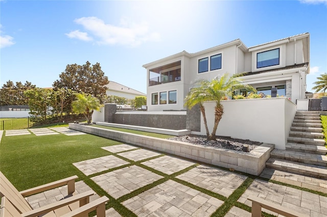 back of property featuring stairway, stucco siding, a lawn, and fence