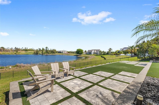 view of patio / terrace with a water view and fence