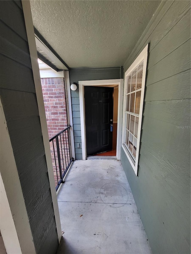 view of exterior entry with a balcony