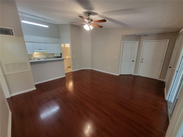 unfurnished living room featuring visible vents, a ceiling fan, a textured ceiling, dark wood-style floors, and baseboards