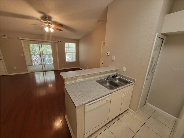 kitchen with dishwasher, light countertops, a peninsula, a ceiling fan, and a sink