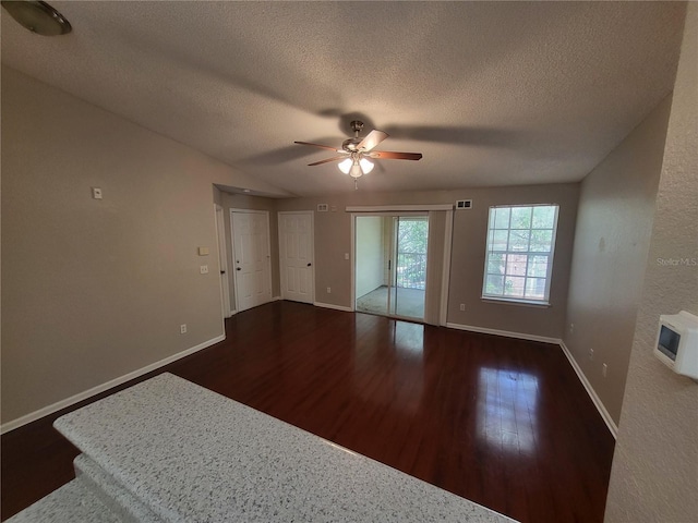 empty room featuring visible vents, baseboards, wood finished floors, a textured ceiling, and a ceiling fan