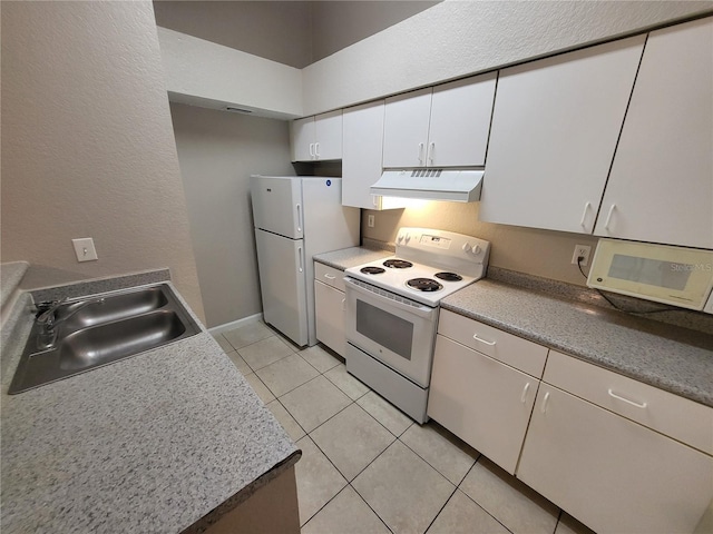 kitchen featuring under cabinet range hood, a sink, white cabinetry, white appliances, and light tile patterned floors