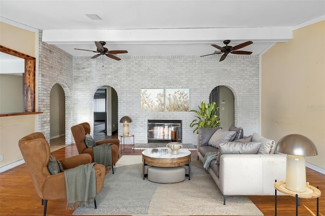 1475 Kettledrum Trl, Deltona, FL 32725 - living area featuring ceiling fan, beamed ceiling, brick wall, a brick fireplace, and wood finished floors