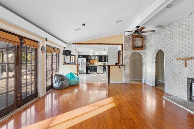 1475 Kettledrum Trl, Deltona, FL 32725 - living area featuring lofted ceiling, a ceiling fan, arched walkways, hardwood / wood-style floors, and a brick fireplace