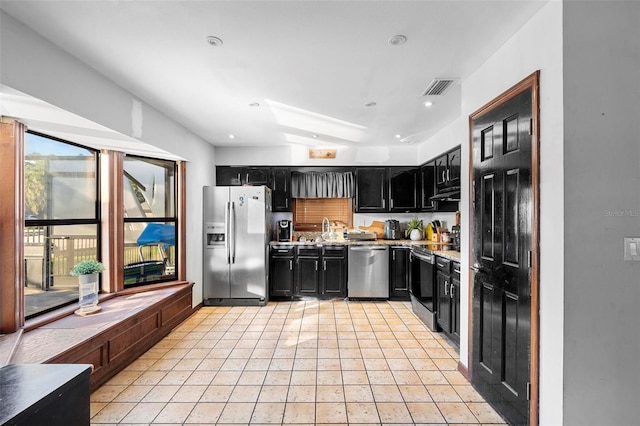 1475 Kettledrum Trl, Deltona, FL 32725 - kitchen featuring stainless steel appliances, dark cabinets, light tile patterned flooring, under cabinet range hood, and a sink