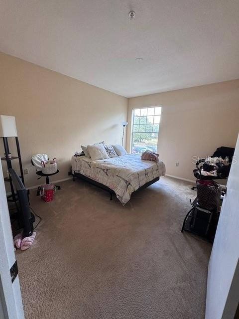 carpeted bedroom featuring baseboards