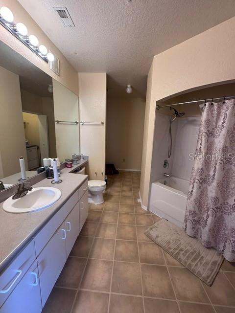 bathroom featuring visible vents, toilet, a textured ceiling, tile patterned flooring, and vanity