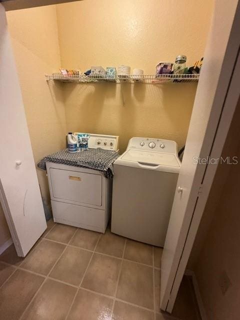 laundry room with light tile patterned floors, separate washer and dryer, and laundry area