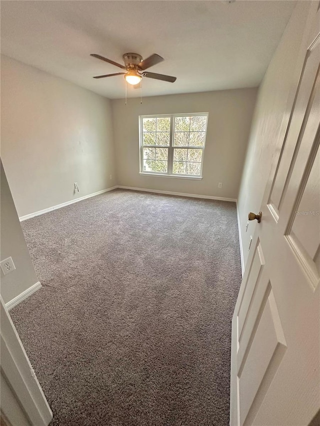 carpeted spare room with baseboards and ceiling fan