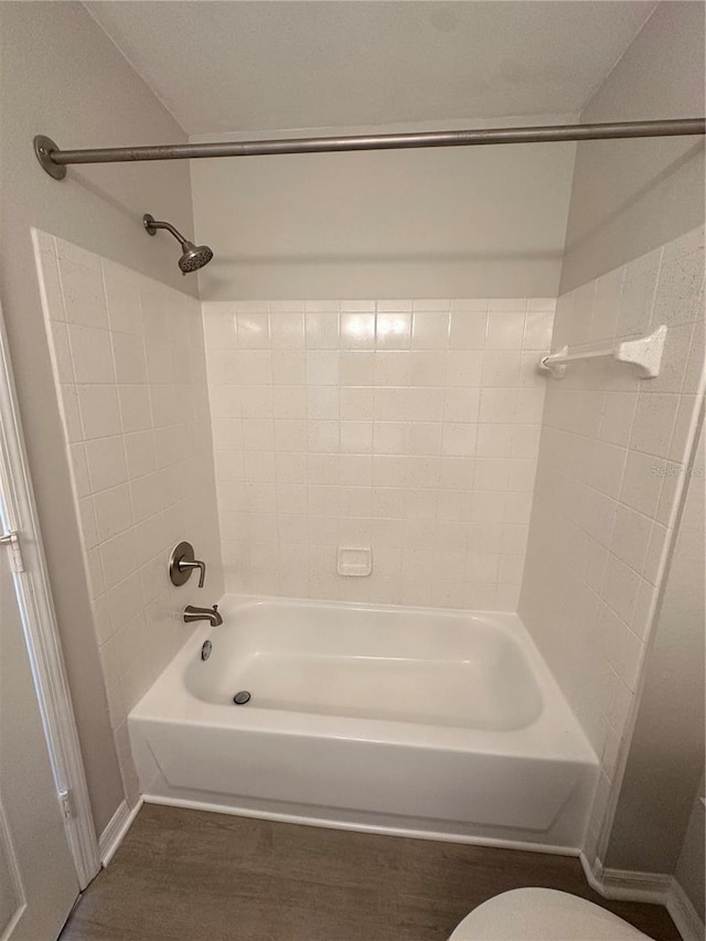 full bath featuring toilet, shower / bathtub combination, baseboards, and wood finished floors