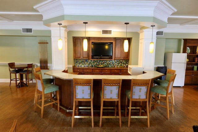 bar with visible vents, backsplash, and freestanding refrigerator