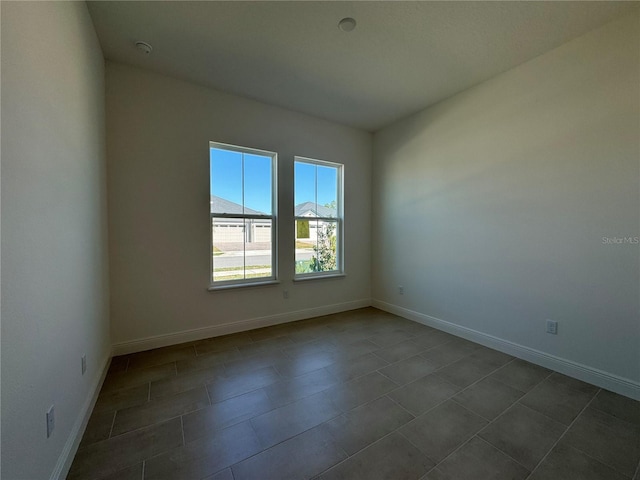 unfurnished room with baseboards