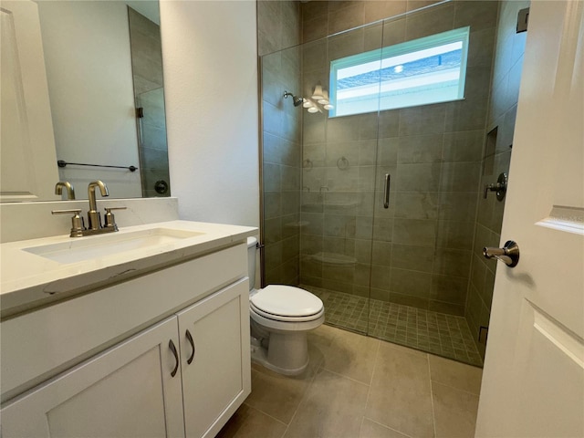 full bathroom featuring vanity, toilet, a stall shower, and tile patterned flooring