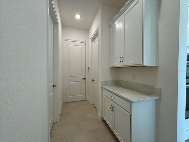 corridor featuring light tile patterned floors and recessed lighting