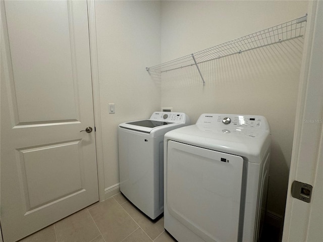 clothes washing area with laundry area, light tile patterned flooring, and separate washer and dryer