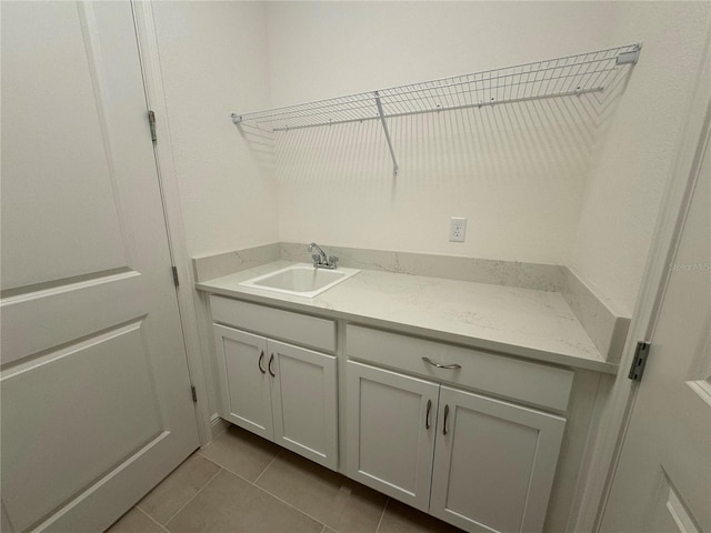 washroom featuring a sink and dark tile patterned flooring