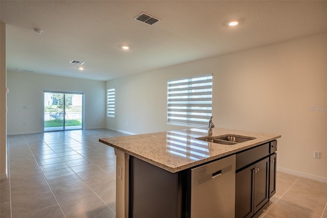 kitchen featuring a sink, visible vents, light tile patterned floors, stainless steel dishwasher, and a kitchen island with sink