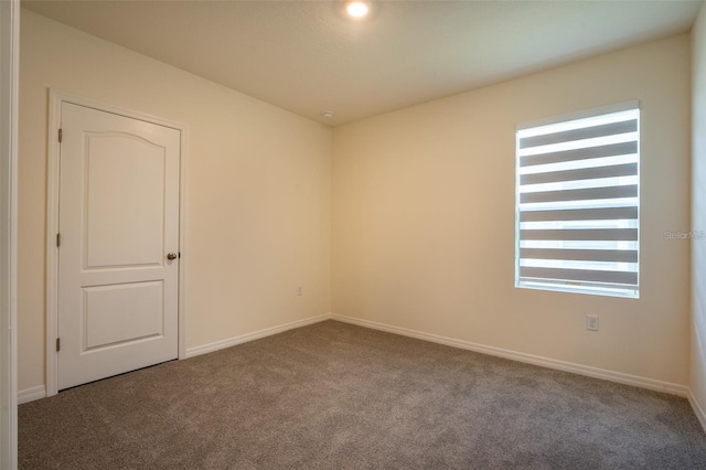 carpeted spare room with baseboards