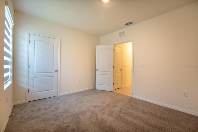 unfurnished bedroom with visible vents, baseboards, and carpet