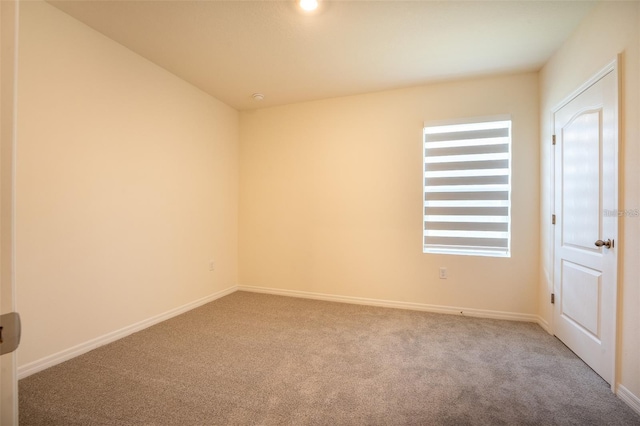 carpeted spare room featuring baseboards